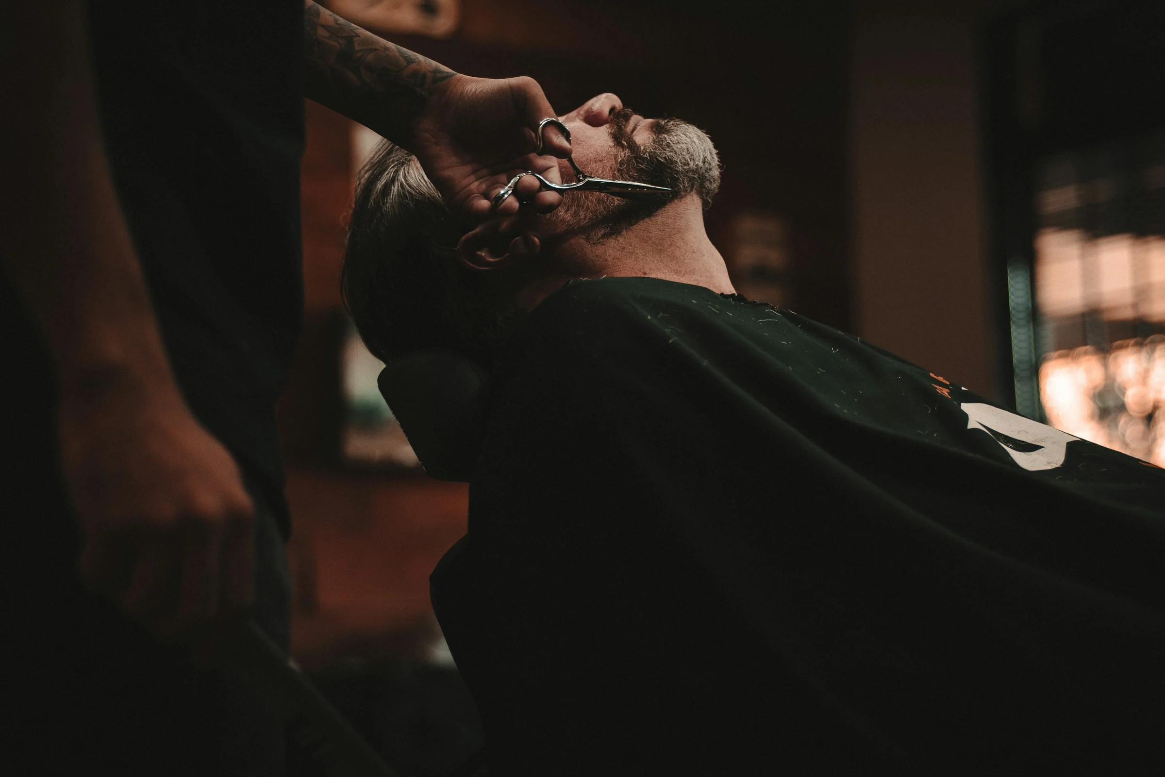 Barbero afeitando a un cliente con navaja